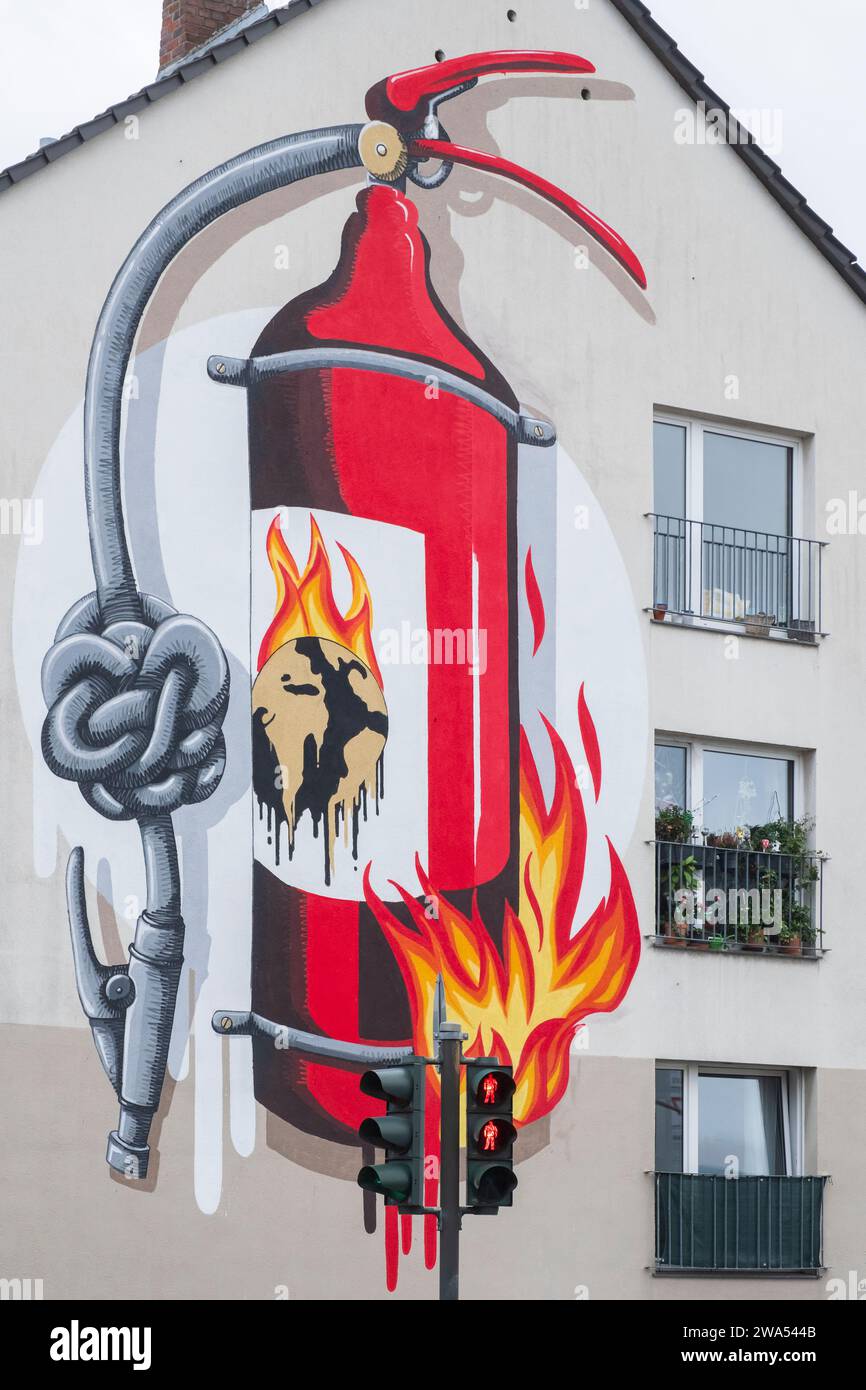 Graffito an einer Hauswand zeigt einen brennenden Feuerlöscher und ein Emblem der brennenden Erde und einen Knoten im Schlauch, der sie nutzlos macht Stockfoto