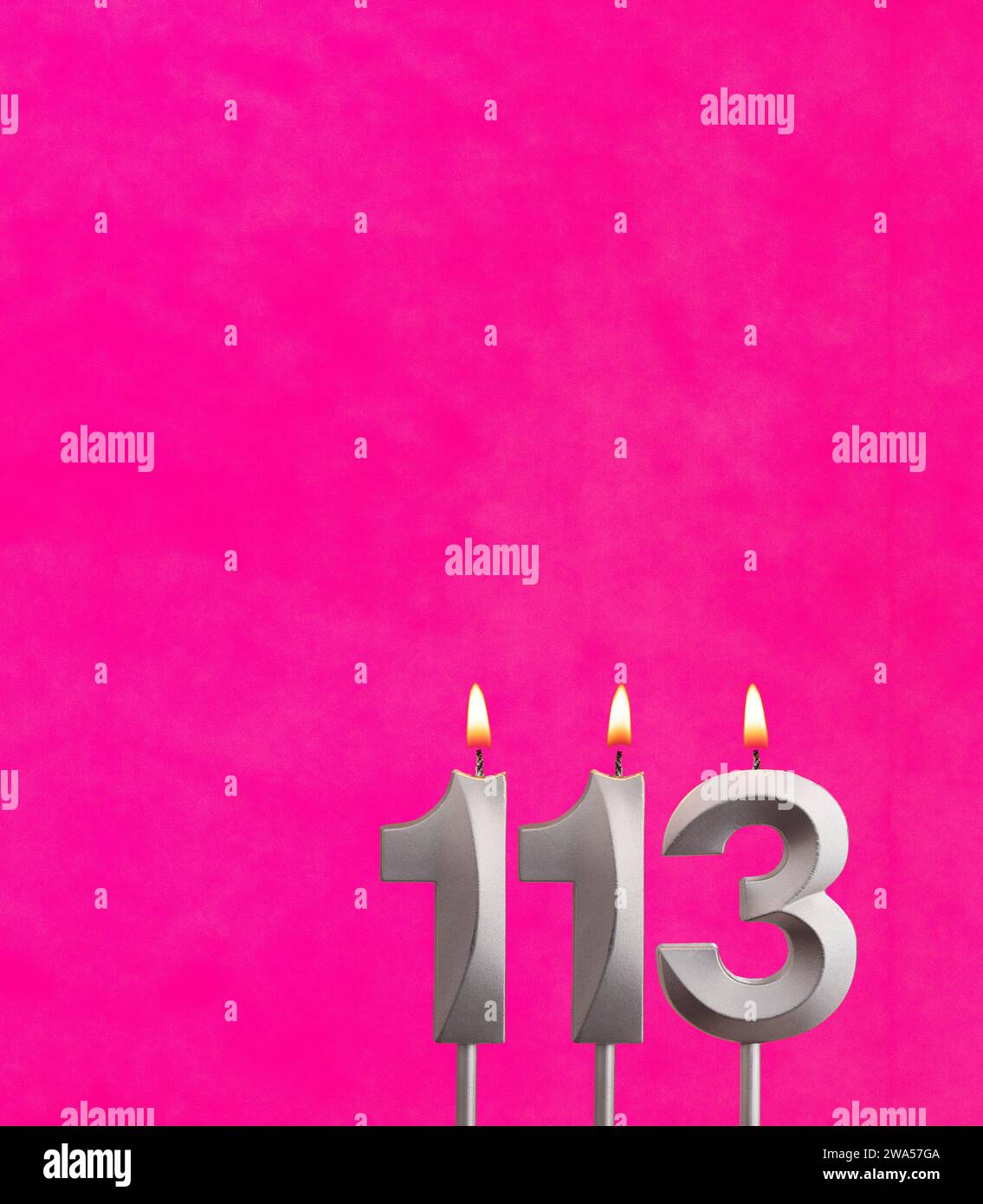 Kerze Nummer 113 - Geburtstagsfeier auf Fuchsia Hintergrund Stockfoto