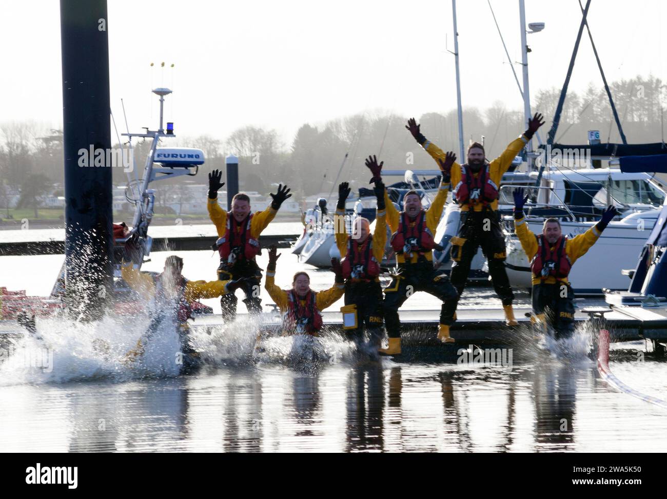 Helensburgh Lifeboat Crew beim New Year Dook in Rhu Marina, Schottland Stockfoto