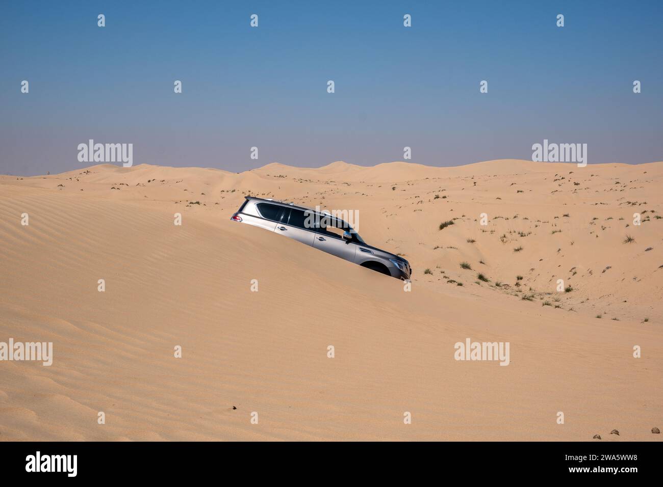 SUV Allradfahrzeug Al Qudra Leerviertel nahtlose Wüste sahara in Dubai VAE im Mittleren Osten mit Windwegen und Sandhügeln grauem, bewölktem Himmel Stockfoto