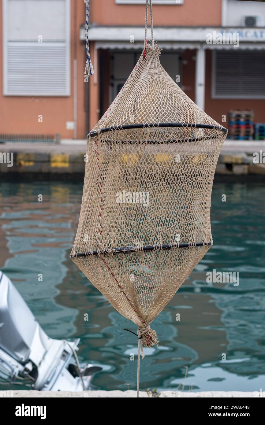 Gegenstände für die Fischerei, die im Hafen von Grado gefunden wurden. Typisches Kepnet, das in das Wasser abgesenkt und in einer bestimmten Tiefe aufgehängt wird. Realistisch. Stockfoto