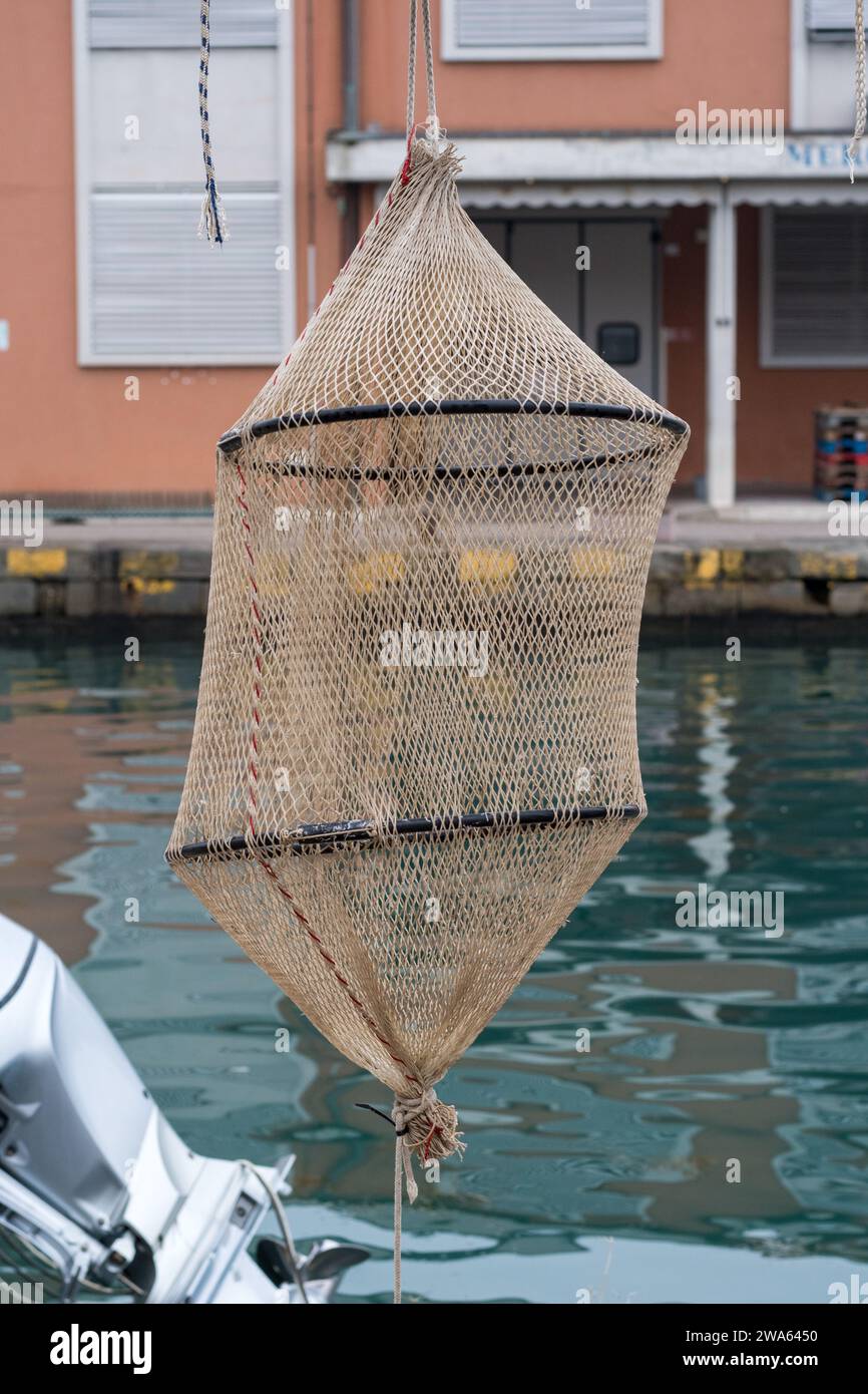 Gegenstände für die Fischerei, die im Hafen von Grado gefunden wurden. Typisches Kepnet, das in das Wasser abgesenkt und in einer bestimmten Tiefe aufgehängt wird. Realistisch. Stockfoto