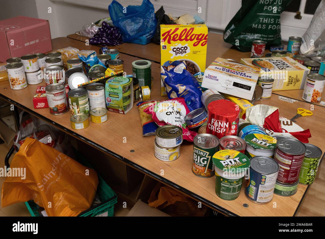 Lebensmittelvorräte im Lagerraum einer Lebensmittelbank in South Kilburn, London. Wenn sie sortiert sind, werden sie an bedürftige Menschen vor Ort gespendet. Stockfoto