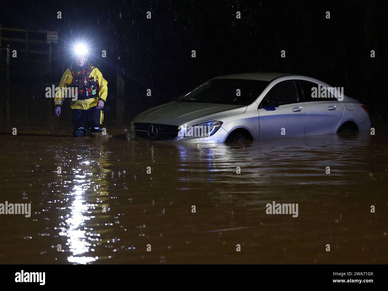 Hathern, Leicestershire, Großbritannien. Januar 2024. Wetter in Großbritannien. Ein Feuerwehrmann überprüft ein Auto, das im Hochwasser gestrandet ist. Starke Winde und heftige Regenfälle treffen einen großen Teil Großbritanniens, als der kleine, aber potente Sturm Henk trifft. Credit Darren Staples/Alamy Live News. Stockfoto