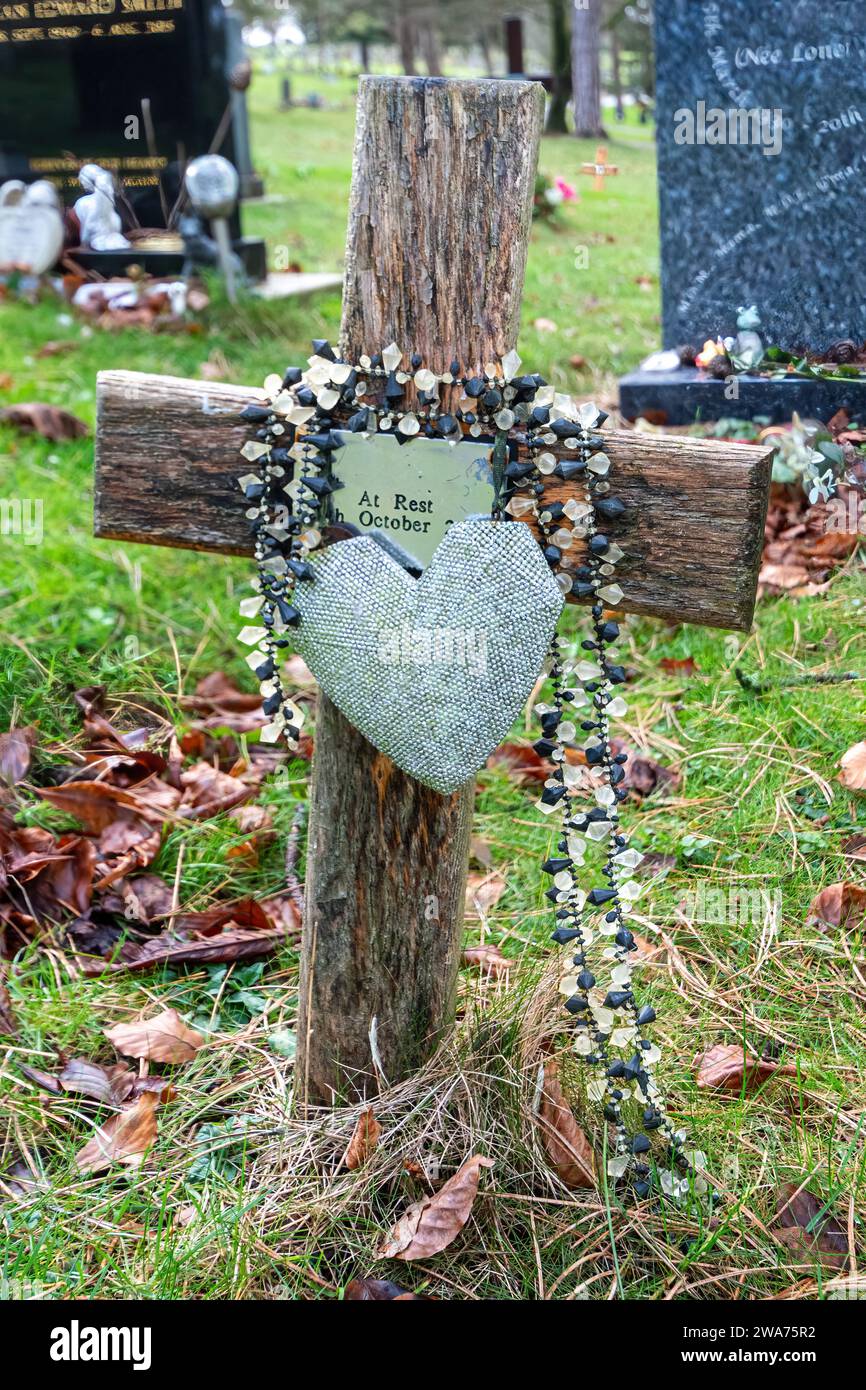 Katholisches Grab auf einem Friedhof, markiert mit einem Holzkreuz mit Rosenkranzperlen, England, Großbritannien. Römisch-katholische Religion Stockfoto
