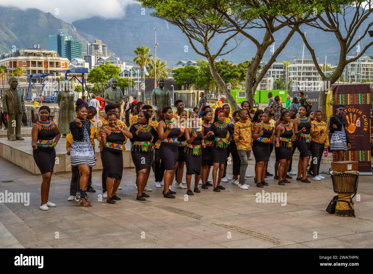 Kinder in traditioneller Zulu-Kleidung tanzen und spielen auf den Straßen von Kapstadt, Südafrika Stockfoto