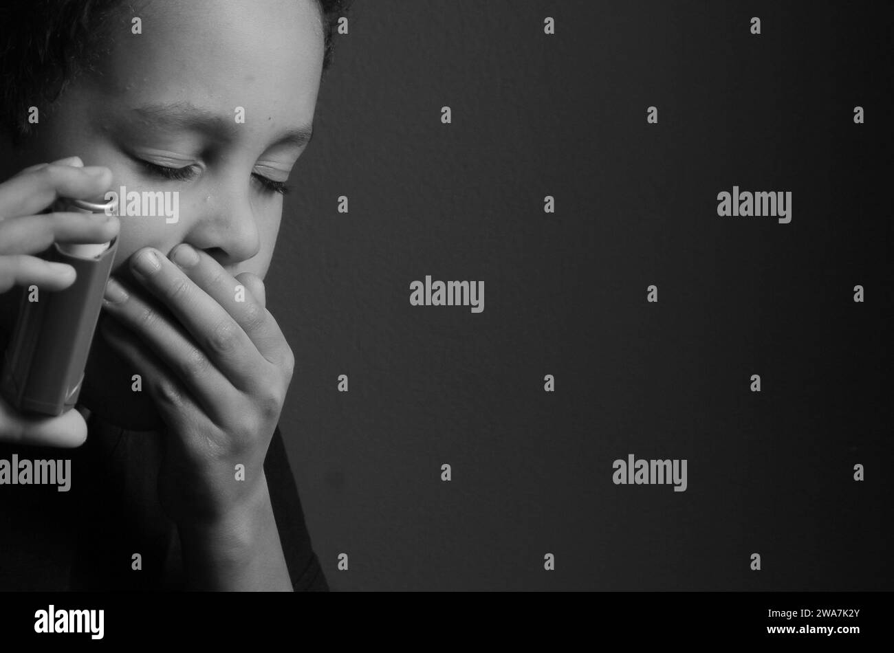 Kind mit Grippe mit Inhalator Atemschutz auf grauem Hintergrund mit Menschen Stockfoto Stockfoto