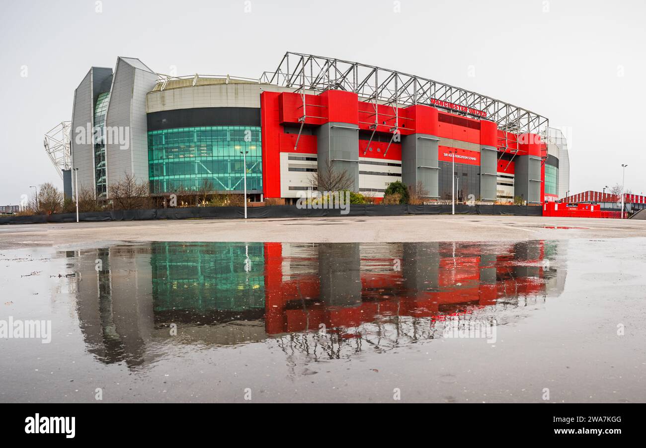 Ein Multi-Bild-Panorama des Old Trafford Stadions, Heimstadion des Manchester United Football Club, spiegelt sich am 2. Januar 2024 in einer großen Pfütze wider. Stockfoto