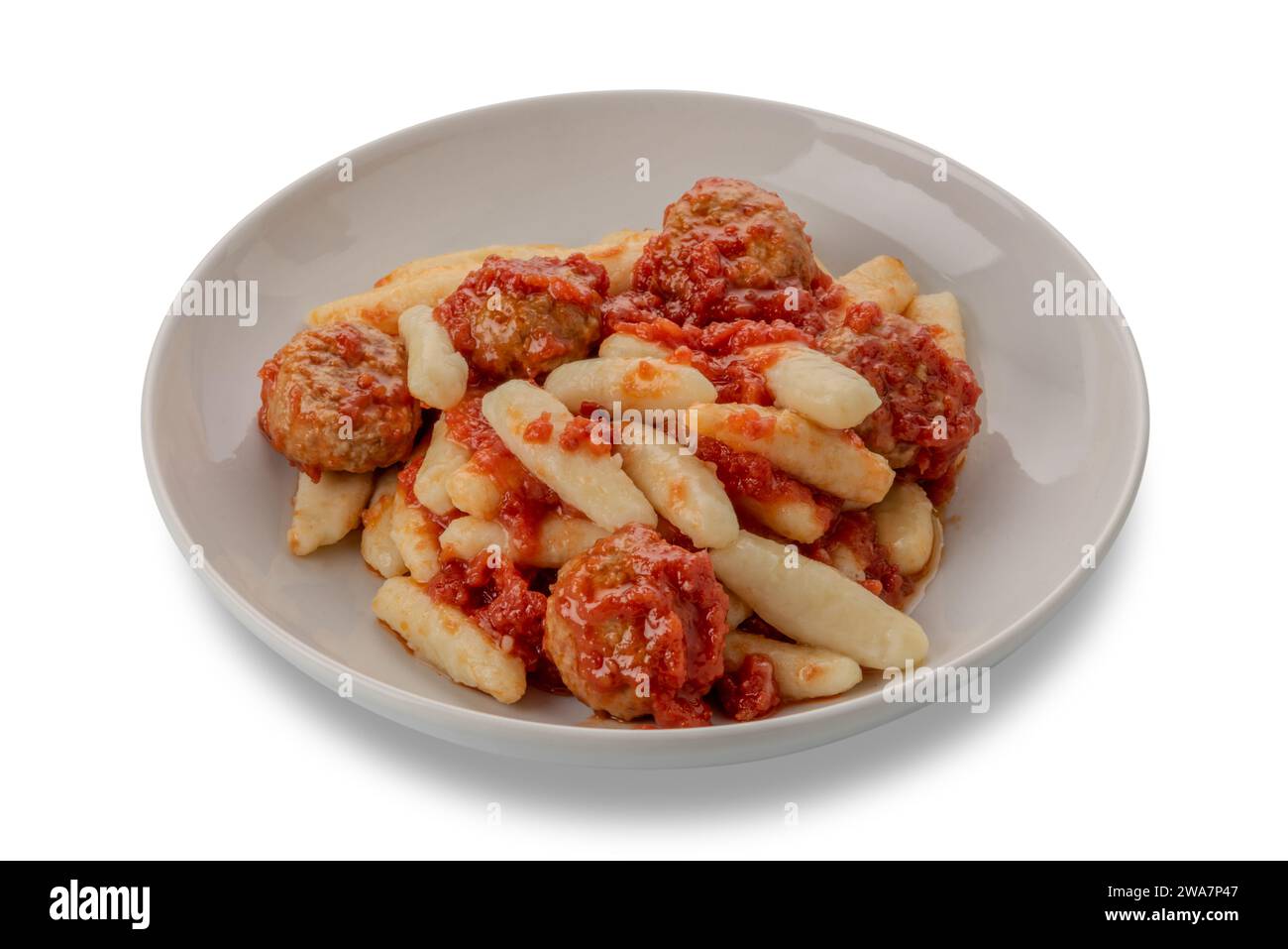 Gnocchi mit Tomatensauce und Fleischbällchen in weißer Platte isoliert auf weiß mit Schnittpfad im Preis inbegriffen. Typische Gnocchi aus den italienischen Alpen. Gnocchi f Stockfoto