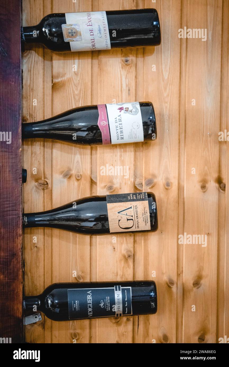 Evora, Alentejo, Portugal. November 2022. Ausstellung von Alentejo-Weinflaschen auf Wandregal in einem rustikalen Restaurant. Stockfoto