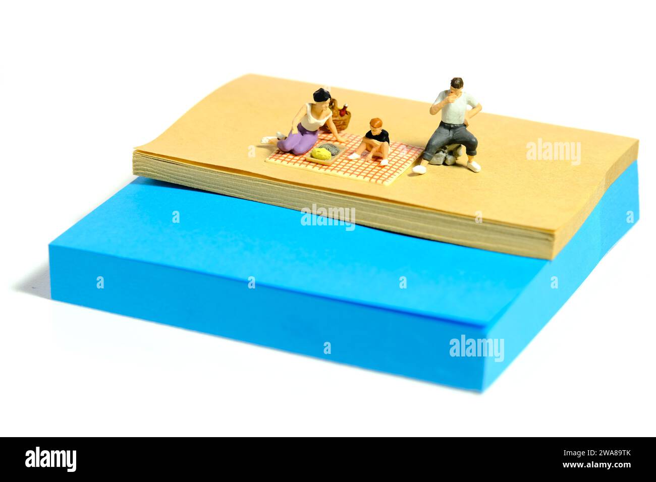 Kreative Miniaturmenschen spielzeugfiguren fotografieren. Installation von Haftnotizen. Familienpicknick am Fluss im Sommerurlaub. Stockfoto