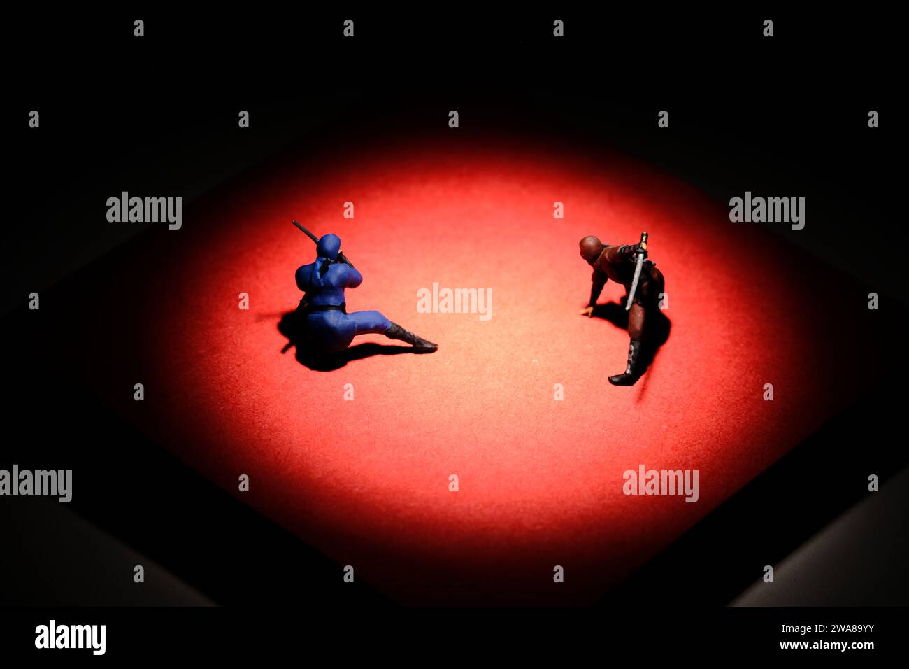 Kreative Miniaturmenschen spielzeugfiguren fotografieren. Installation von Haftnotizen. Zwei Ninja kämpfen in der Red Mat Arena. Bild Foto Stockfoto