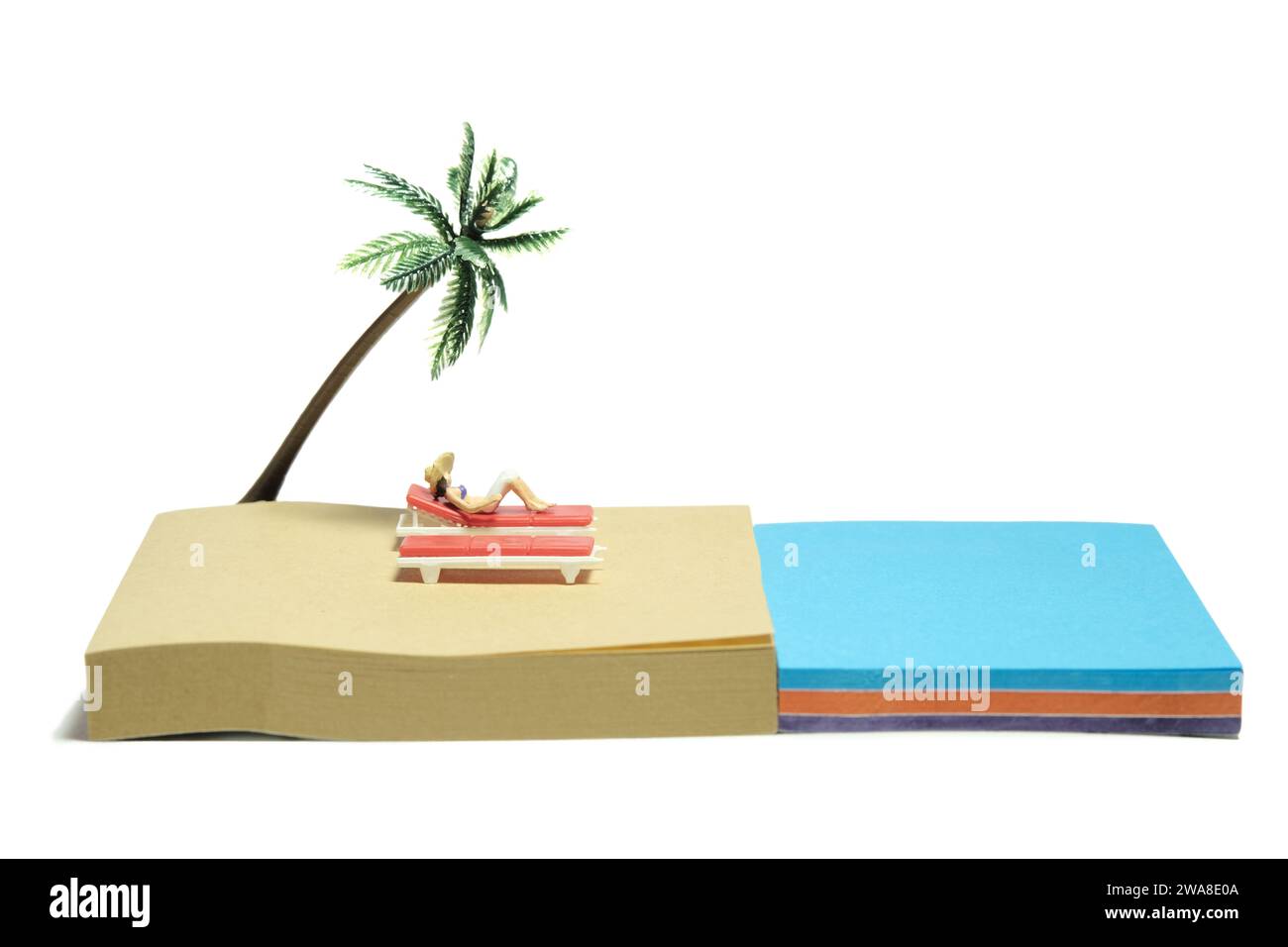 Kreative Miniaturmenschen spielzeugfiguren fotografieren. Installation von Haftnotizen. Ein Mädchen, das auf der Strandbank am Strand unter Kokospalmen chillt. Isola Stockfoto