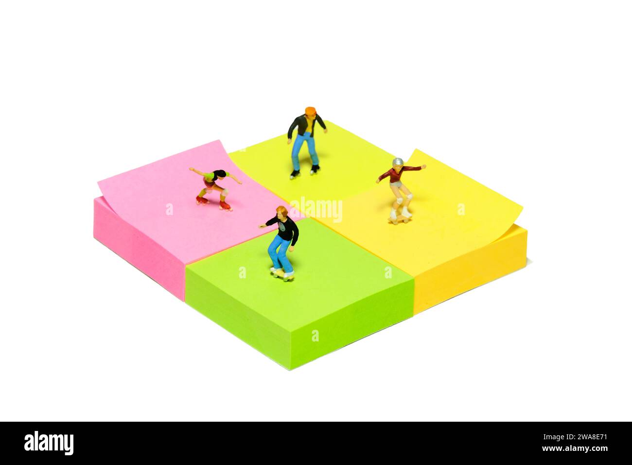 Kreative Miniaturmenschen spielzeugfiguren fotografieren. Installation von Haftnotizen. Kinder spielen Rollschuhläufer im Skatepark. Isoliert auf weißem Hintergrund. Stockfoto