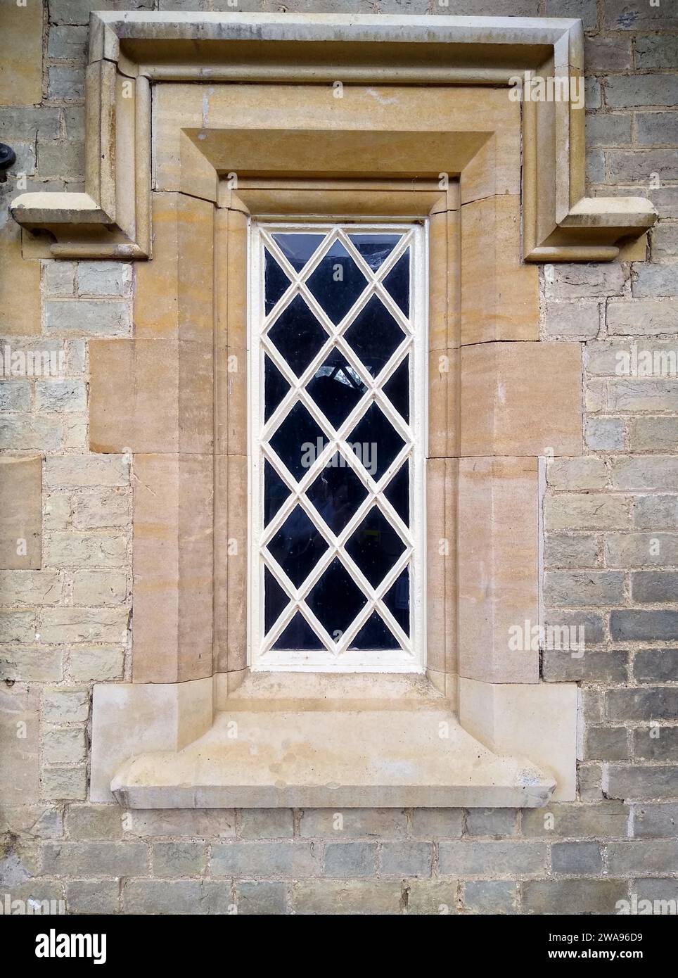 Altes Fenster in der Steinmauer eines alten englischen Hauses. England Stockfoto