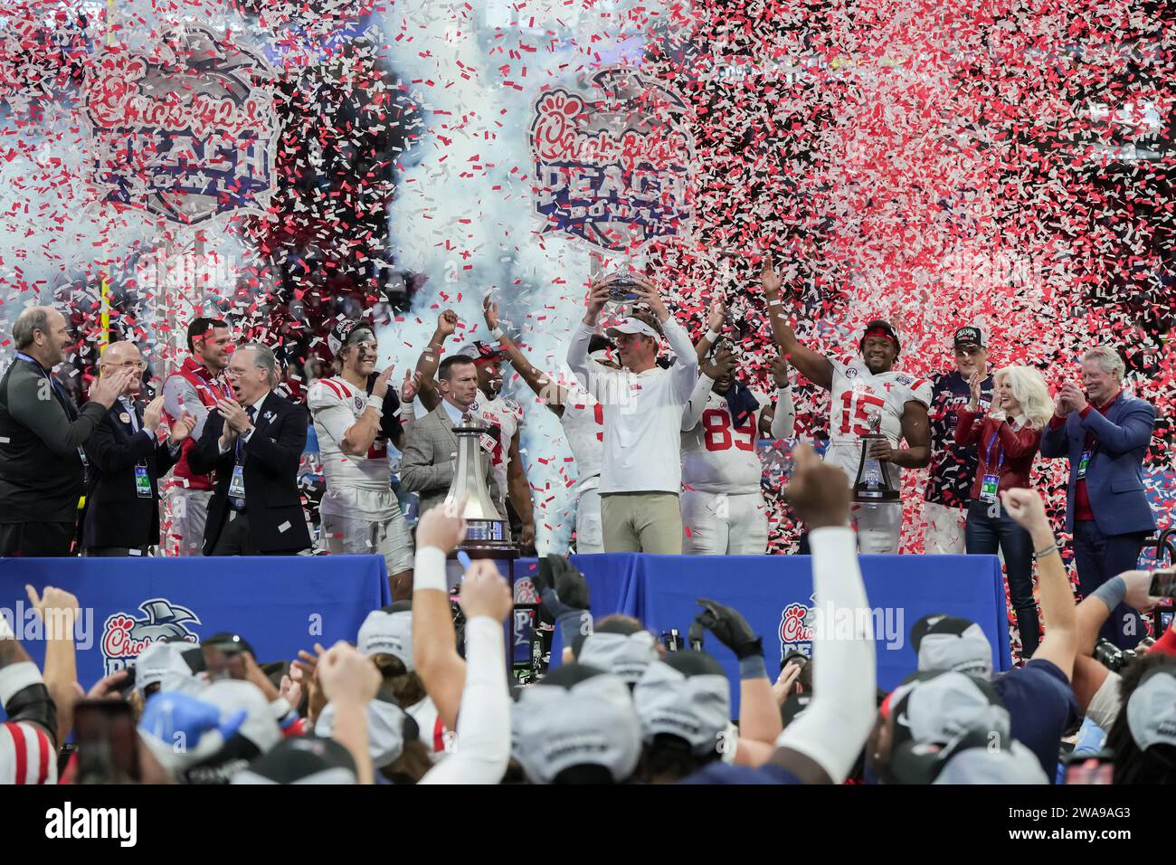 Lane Kiffin, Cheftrainer der Mississippi Rebels, hält die Pfirsichschale-Trophäe, während einige der Hauptspieler der Mississippi Rebels am 1. Januar 2023 im Mercedes-Benz Stadium in Atlanta, Georgia, mit Chick-Fil-A Peach Bowl College Football-Spiel zwischen Pen State und Mississippi Rebels feiern. Mississippi Rebels schlagen Pen State 38-25 (David Venezia / Image of Sport) Stockfoto