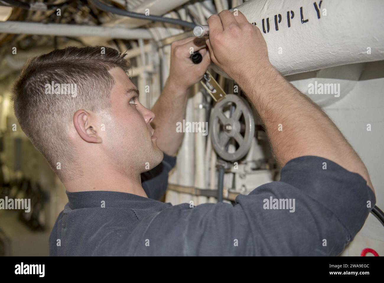 US-Streitkräfte. 180707DZ642-0050 ATLANTISCHER OZEAN (7. Juli 2018) Elektroniker der 2. Klasse Jacob Williams schabloniert ein Rohr in einem Durchgang an Bord des Lenkraketenkreuzers USS Normandie (CG 60). Die Normandie ist derzeit Teil der Harry S. Truman Carrier Strike Group. Mit Harry S. Truman als Flaggschiff wurden Stab, Schiffe und Flugzeuge der Carrier Strike Group (CSG) 8, der Destroyer Squadron (DESRON) 28 und des Carrier Air Wing (CVW) 1 sowie der Sachsen-Klasse FGS Hessen (F 221) eingesetzt. (Foto der US Navy von Mass Communication Specialist 2n Stockfoto