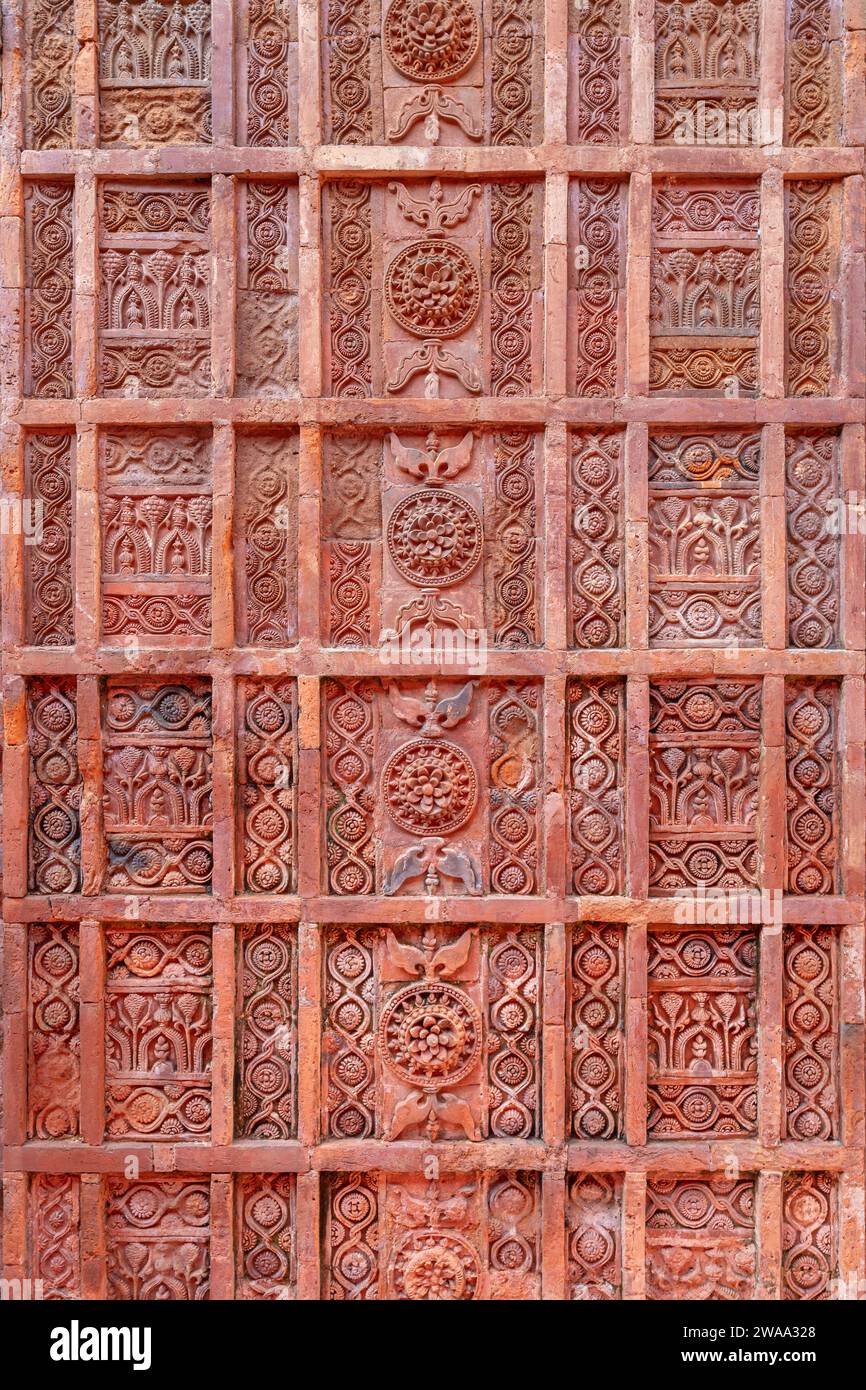 Vertikale Nahaufnahme der delikaten antiken Terrakotta-Schnitzerei mit floralem und geometrischem Muster auf der Fassade der Atiya-Moschee, Tangail, Bangladesch Stockfoto