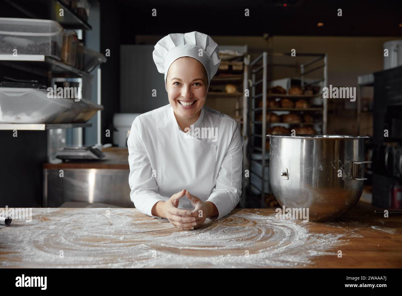Porträt einer glücklichen Bäckerin mit lächelndem Gesicht in Uniform Stockfoto