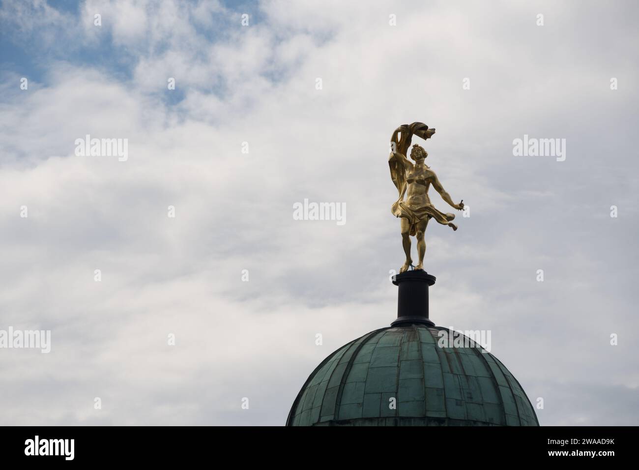 Eine vergoldete Statue glänzt auf einer klassischen Kuppel in Potsdam, eine atemberaubende Darstellung des künstlerischen Erbes und der historischen Pracht der Stadt. Stockfoto