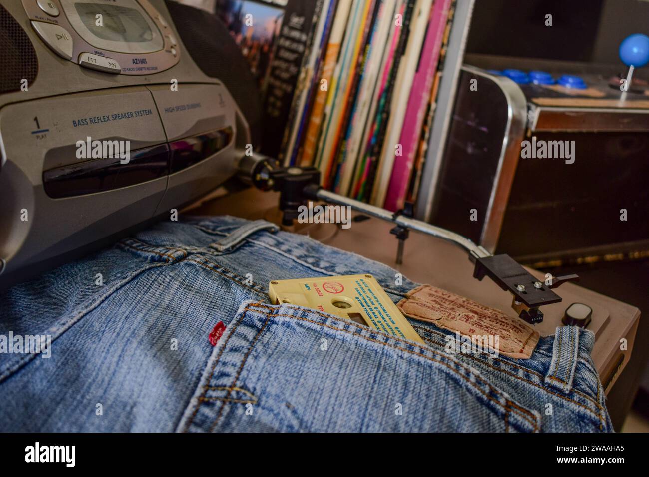 Neunziger-Jahre-Retro-Setup mit Kassettenspieler, Schallplatten und Jeans. Stockfoto