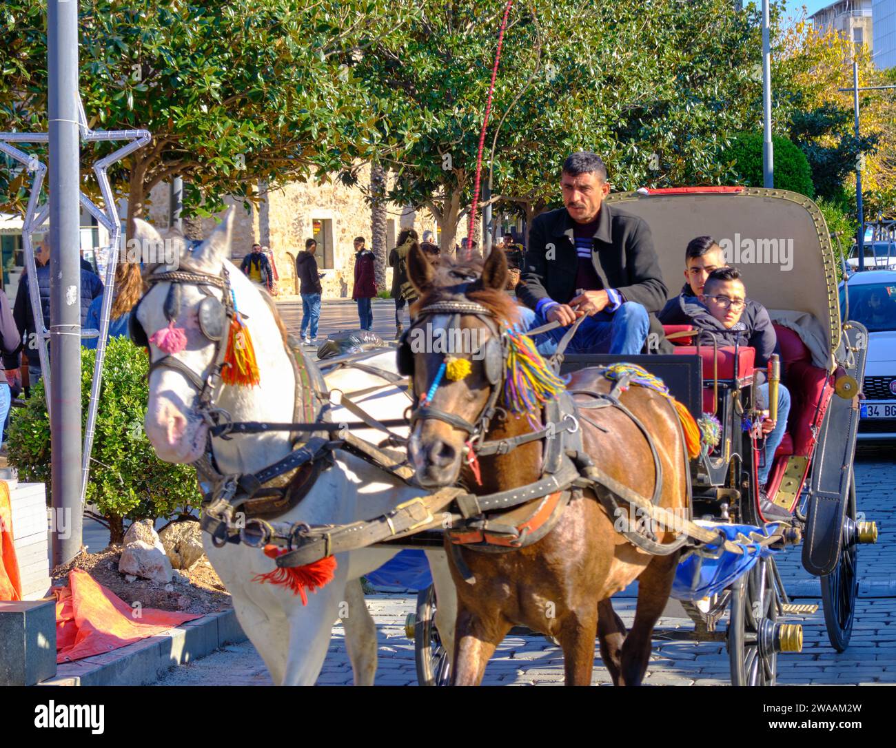 Pferdekutsche mit Fahrer und Passagieren auf der Stadtstraße von Antalya, Türkei - 30. Dezember 2018 Stockfoto