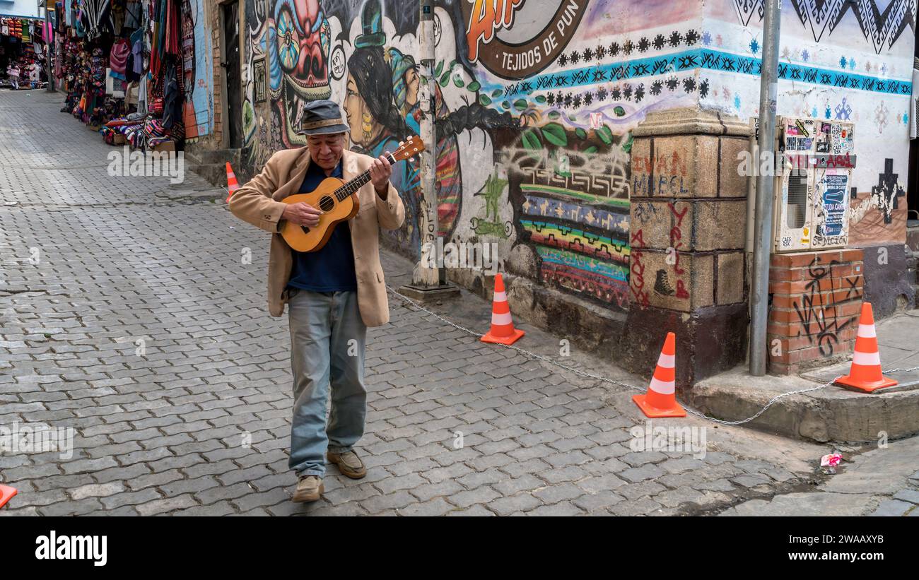 Cusco, Peru - 24. Oktober 2023: Ein peruanischer Mann, der Gitarre spielt und singt, auf der Straße der Stadt spaziert Stockfoto