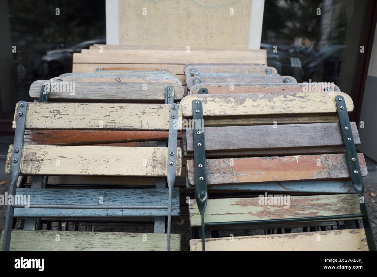 Gepackte Klappstühle aus Holz in alten verfallenen Farbtönen Stockfoto