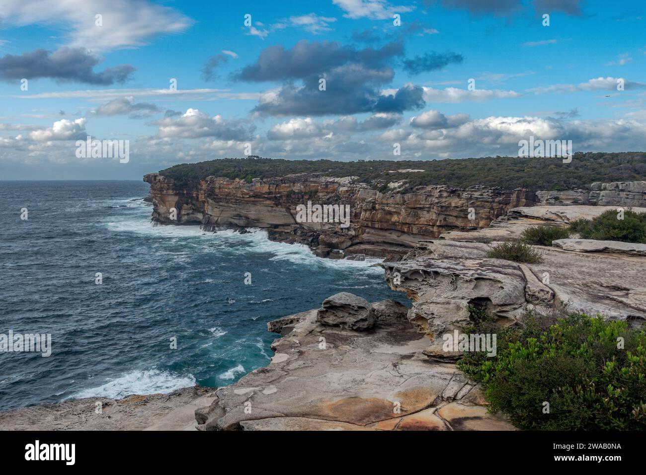 Blick auf die Küstenklippen und das Meer zwischen Maroubra Beach und Malabar Beach, Sydney, Australien. Dramatische Wolkenformationen am blauen Himmel. Stockfoto