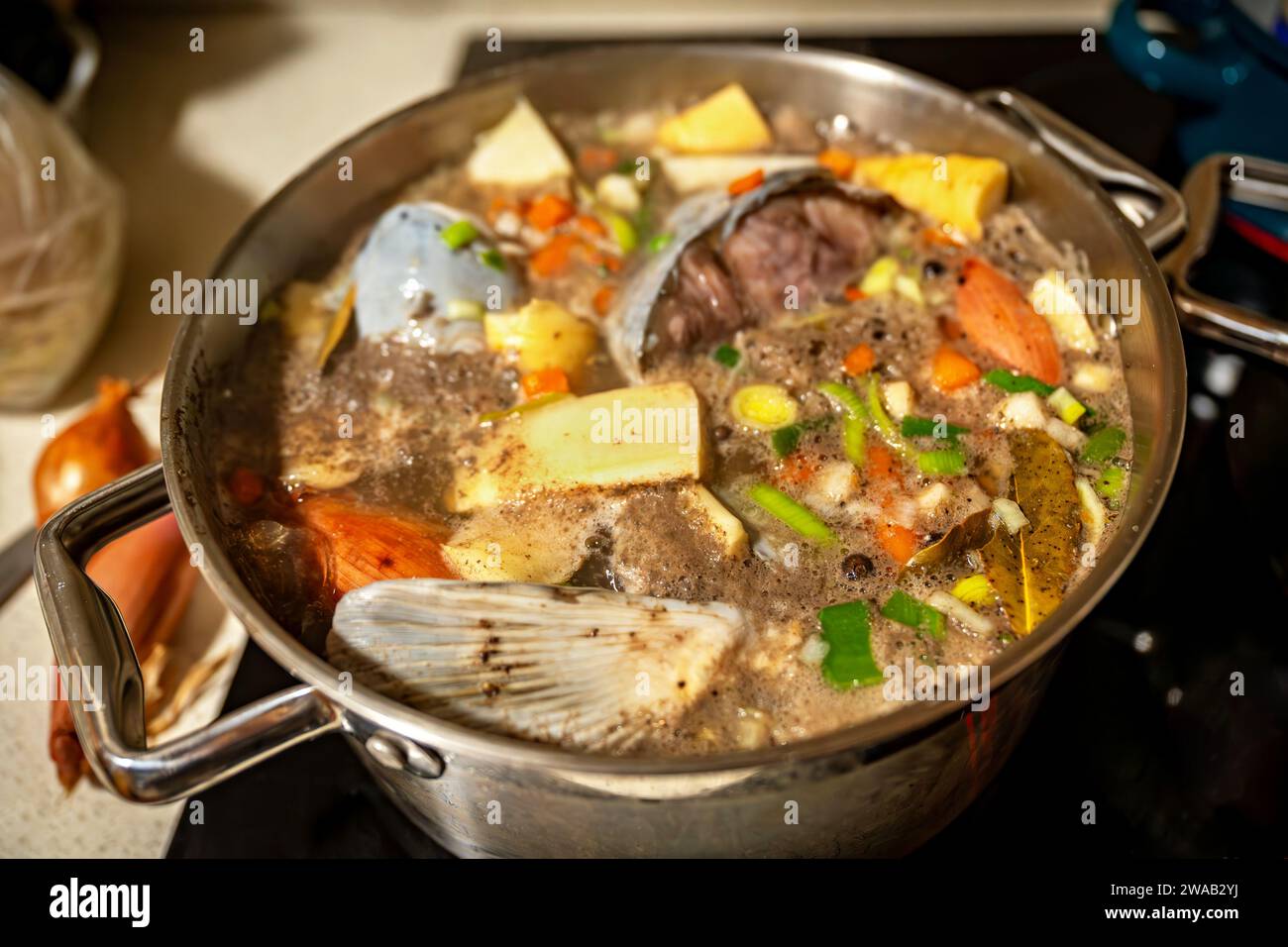Zubereitung von Fischsuppe aus Karpfen mit Gemüse im Topf auf dem Herd, Nahaufnahme. Stockfoto