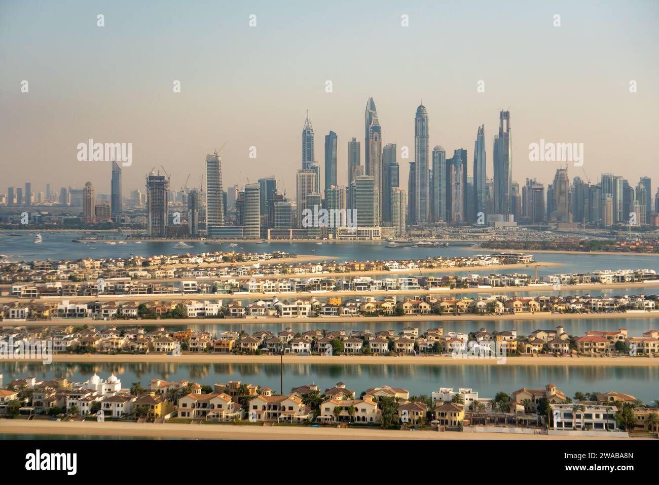Blick aus der Vogelperspektive auf die Luxusvillen von Palm Island und die Skyline von Dubai Marina, VAE. Trüber Himmel, Verschmutzung durch die Stadt. Futuristische Skyline Stockfoto