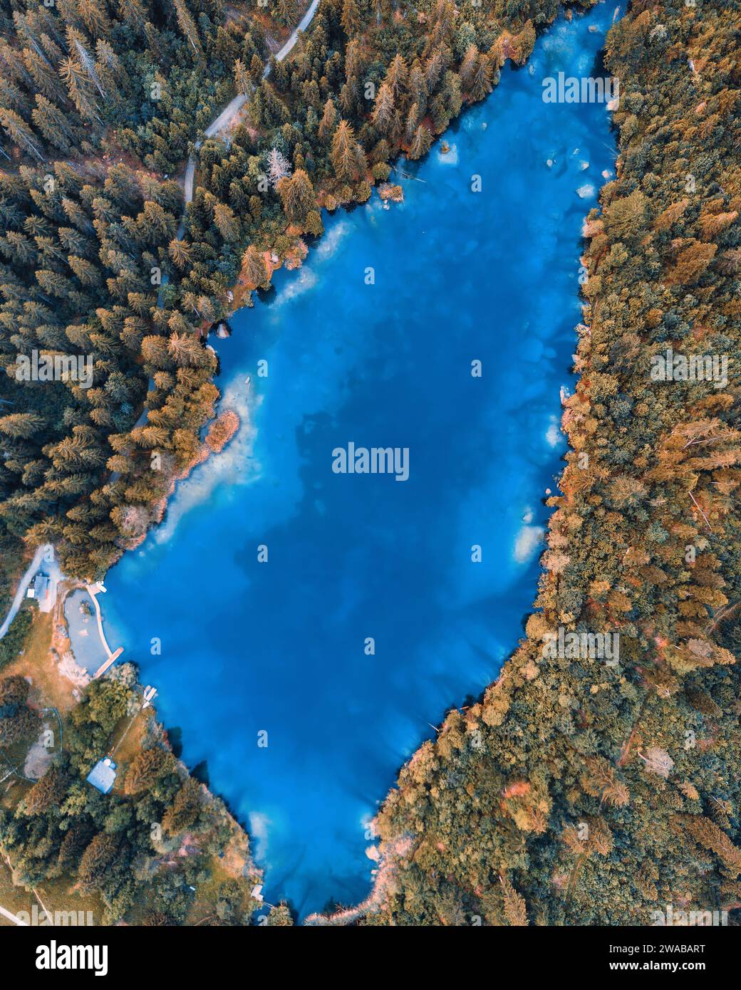 Arieal Blick auf Blue Water in einem Bergwald Baduk See mit Kiefern. Aus der Vogelperspektive in den Bergen auf einem blauen See und grünen Wäldern. Auf dem anzeigen Stockfoto