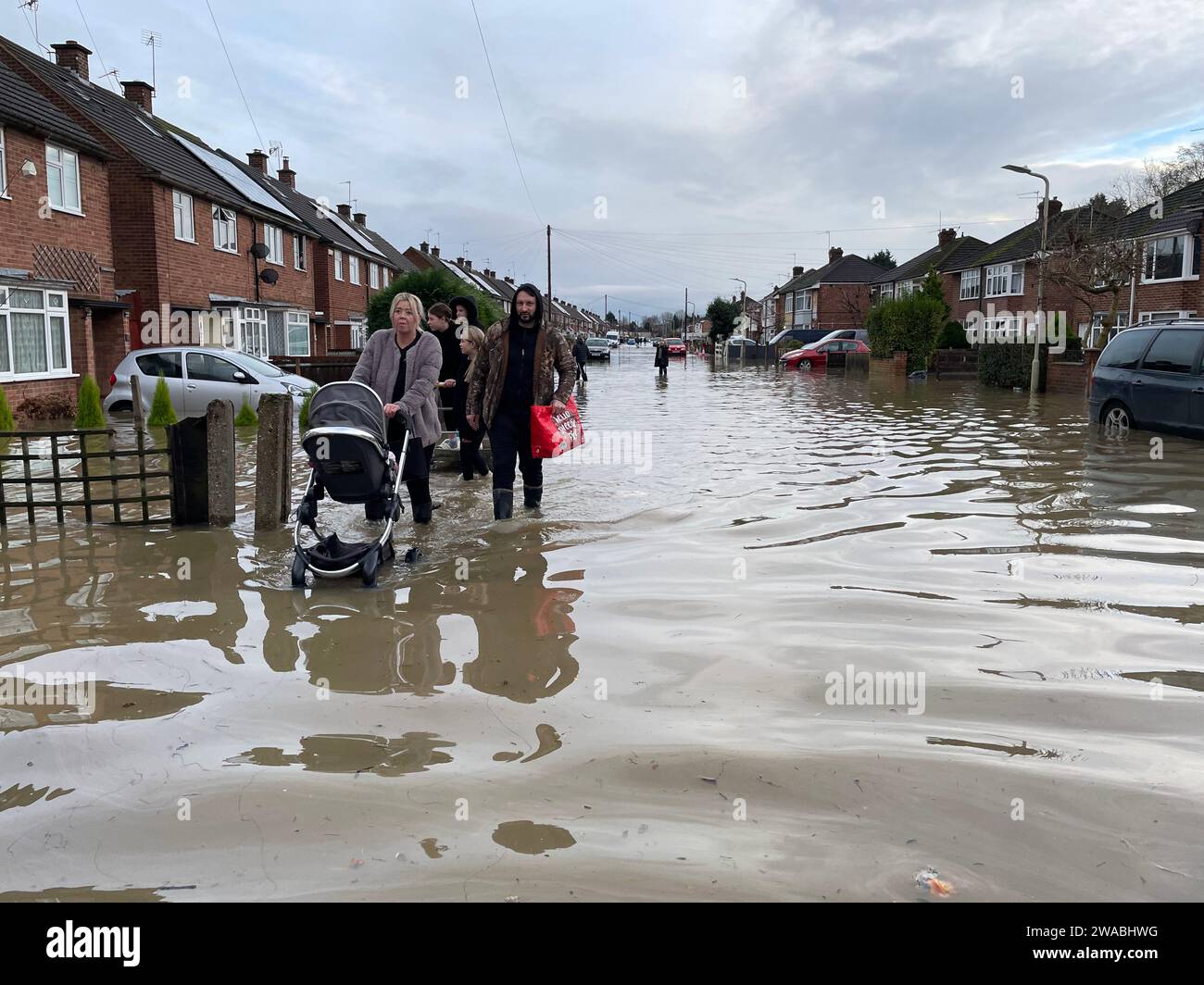 Die Bewohner waten durch Hochwasser in Loughborough, Leicestershire, nachdem Regen und starke Winde vom Sturm Henk große Teile Großbritanniens verwüsteten. Bilddatum: Mittwoch, 3. Januar 2024. Stockfoto