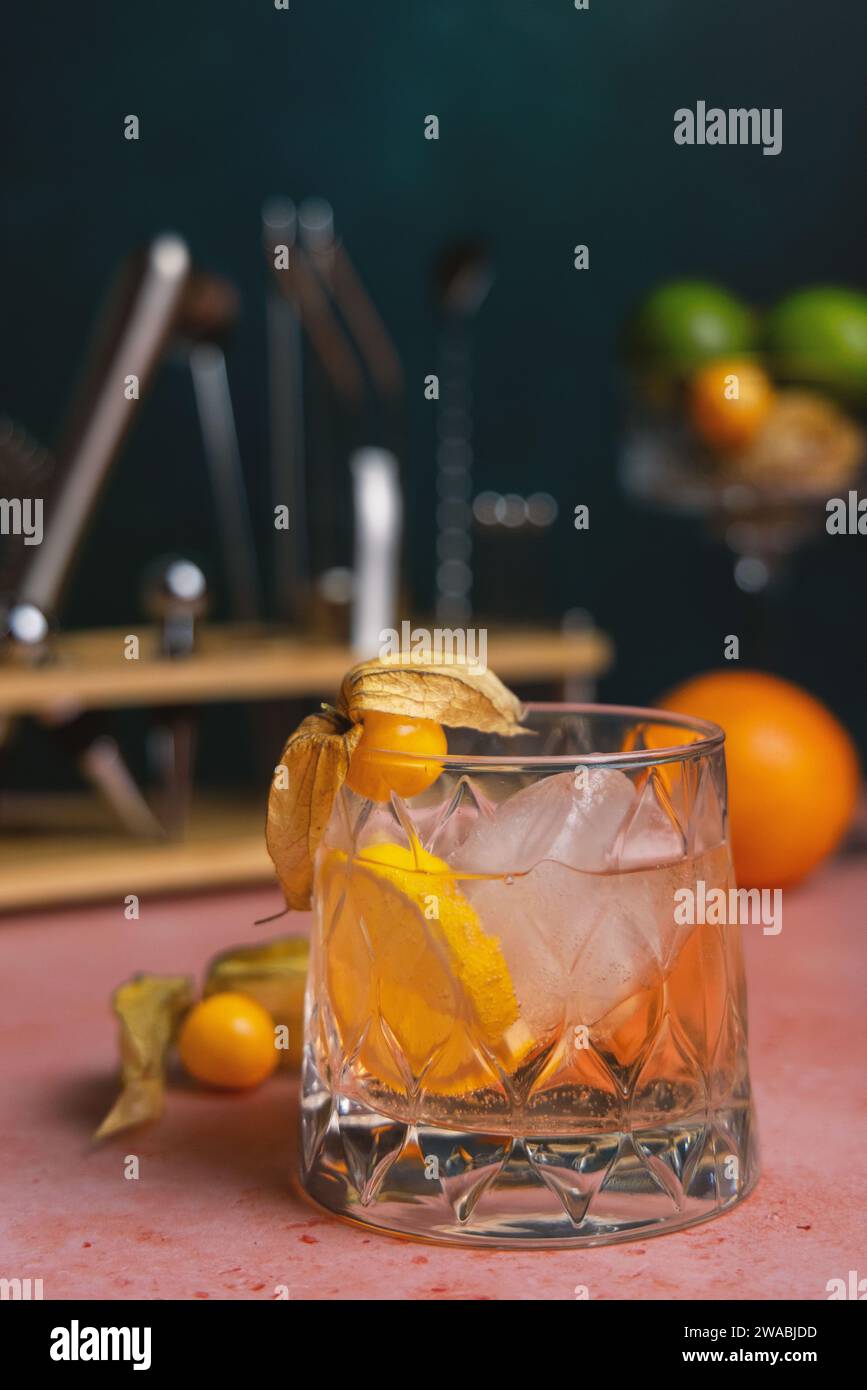 Farbenfroher Cocktail mit Barstützen und frischem Obst im Hintergrund Stockfoto