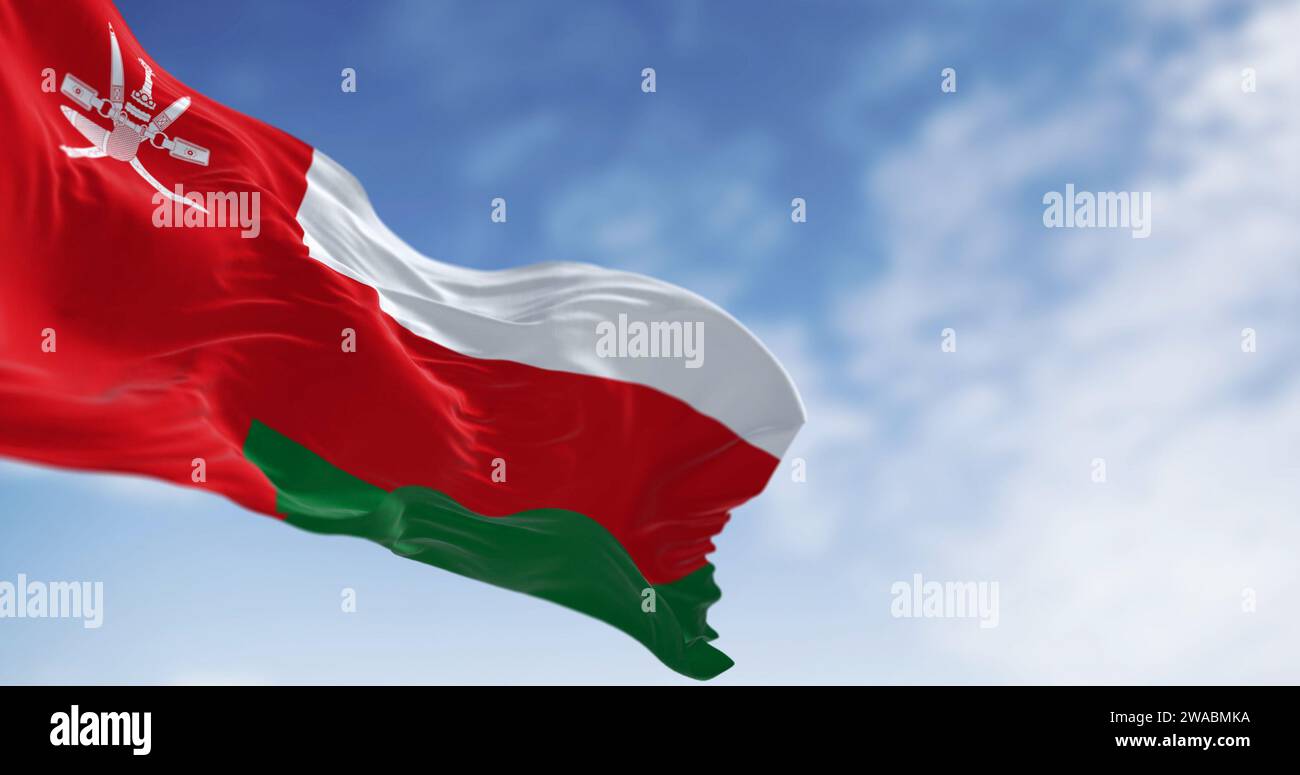 Nationalflagge von Oman winkt an einem klaren Tag im Wind. Vertikaler roter Streifen mit Oman-Emblem und drei horizontalen Streifen: Weiß, rot und grün. 3D Stockfoto