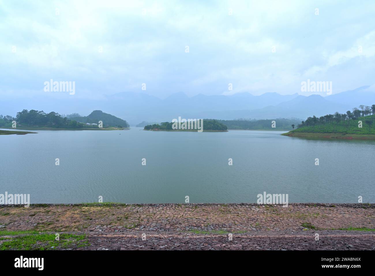 Anayirankal Dam | rosafarbene Steine in der Mitte des Vordergrunds am Seeufer Stockfoto