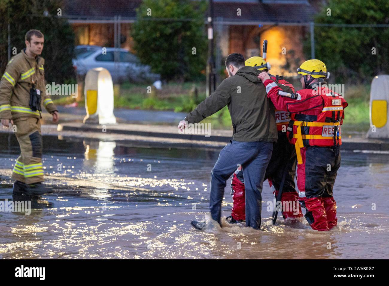 Zu Beginn des Jahres 2024 sah Sturm Henk große Teile der Midlands nach schweren Überschwemmungen unter Wasser. Im Bild retten Feuerwehrleute einen Autofahrer und führen ihn während der Überschwemmung in Sicherheit. Die Rettung fand auf der Tamworth Road B5000 im Dorf Polesworth in North Warwickshire statt, wo Fahrzeuge im tiefen Wasser eingeschlossen waren. Stockfoto