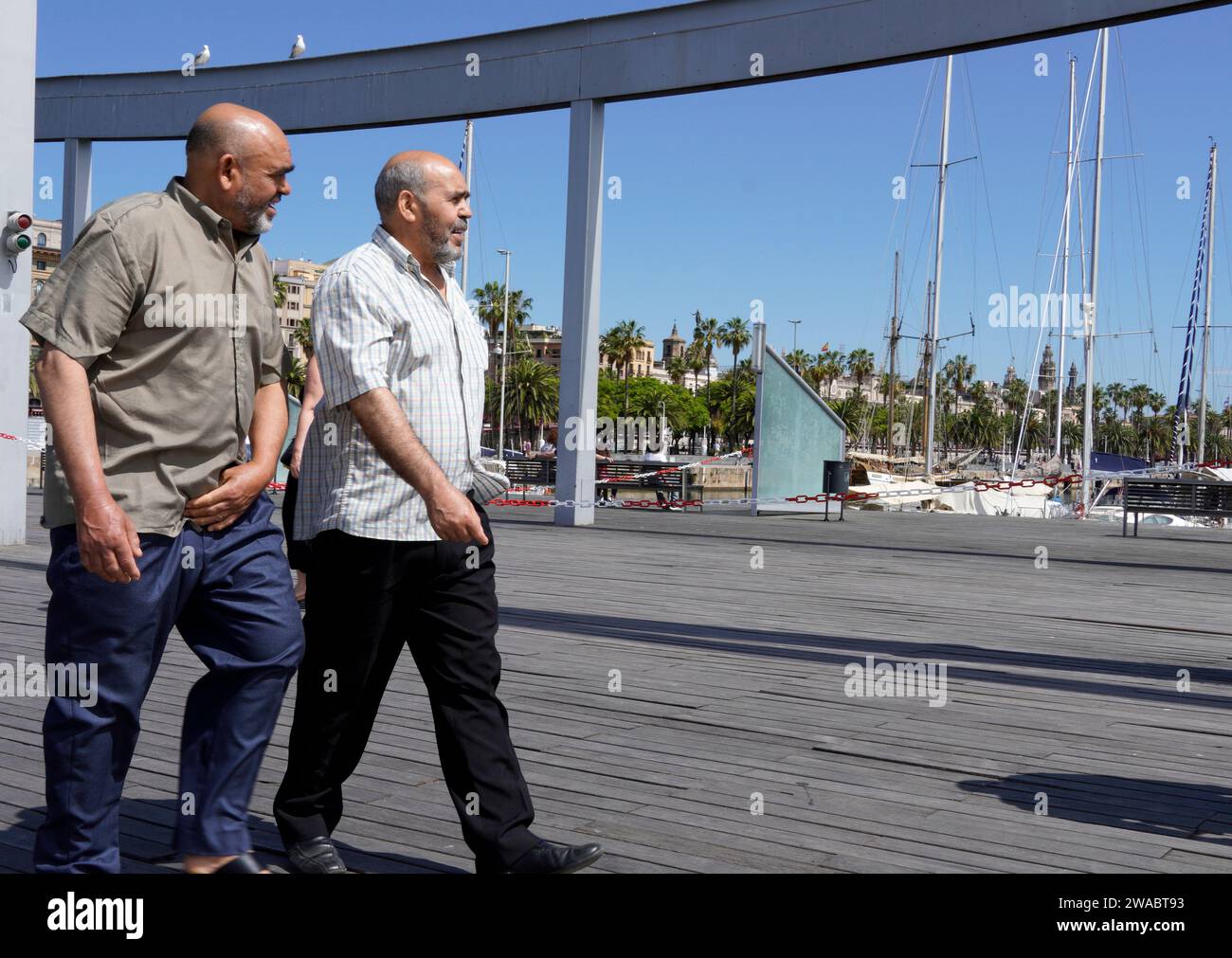 Barcelona, Spanien - 26. Mai 2022: Zwei Brüder spazieren gemeinsam entlang der Rambla del Mar in Richtung des Aquariums von Barcelona. Stockfoto