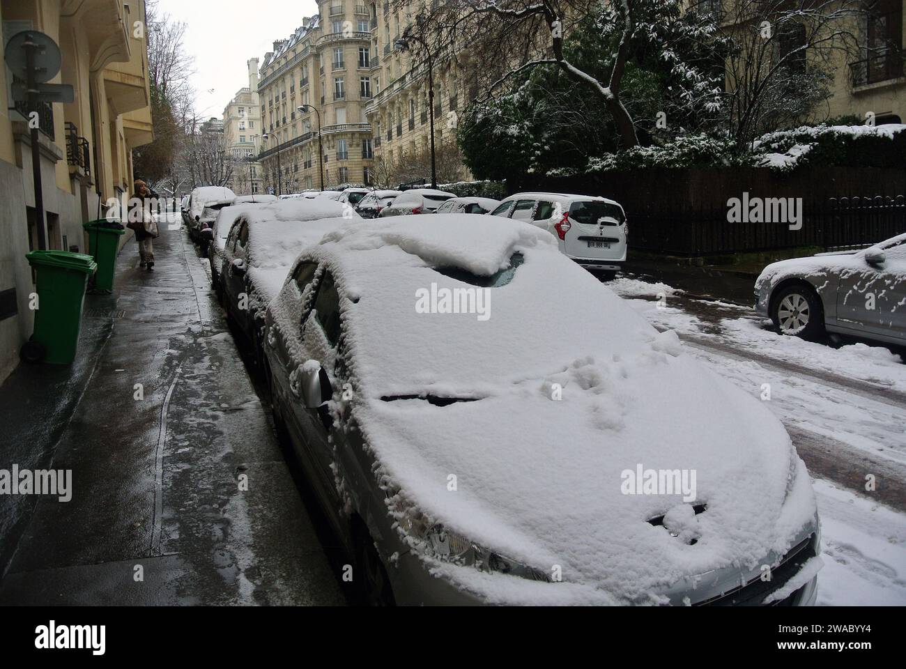 Unerwarteter Schnee in Paris. Straße, Autos mit Schnee bedeckt. Stockfoto