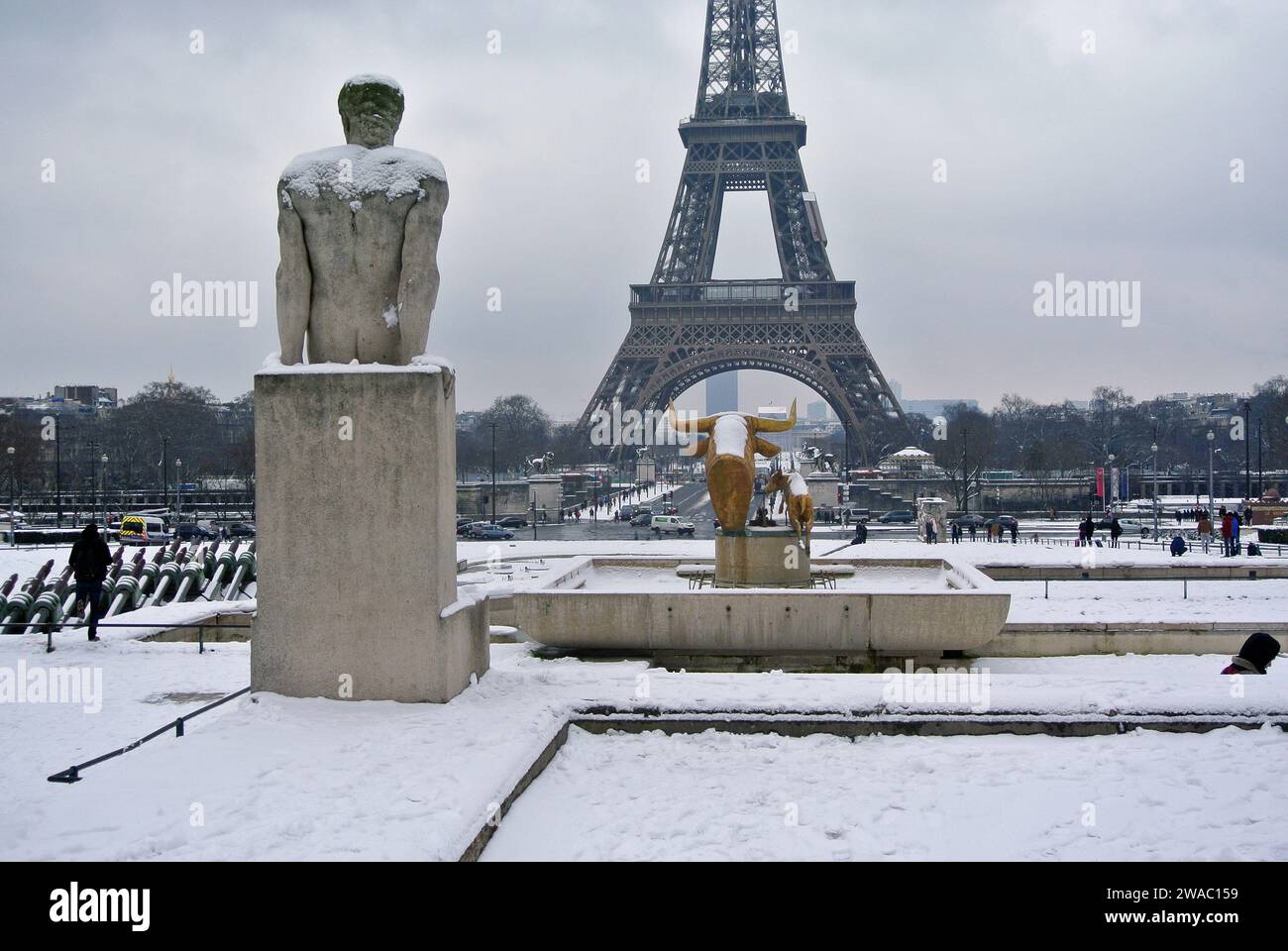 Unerwarteter Schnee in Paris. Trocadero-Garten. Steinskulpturen „Mann“ und „Frau“ sind mit Schnee bedeckt. Stockfoto