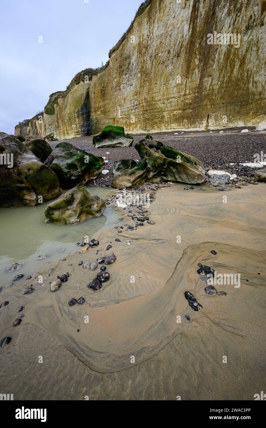 Ebbe mit Sand und Felsen an einem Strand mit Kreidefelsen Stockfoto