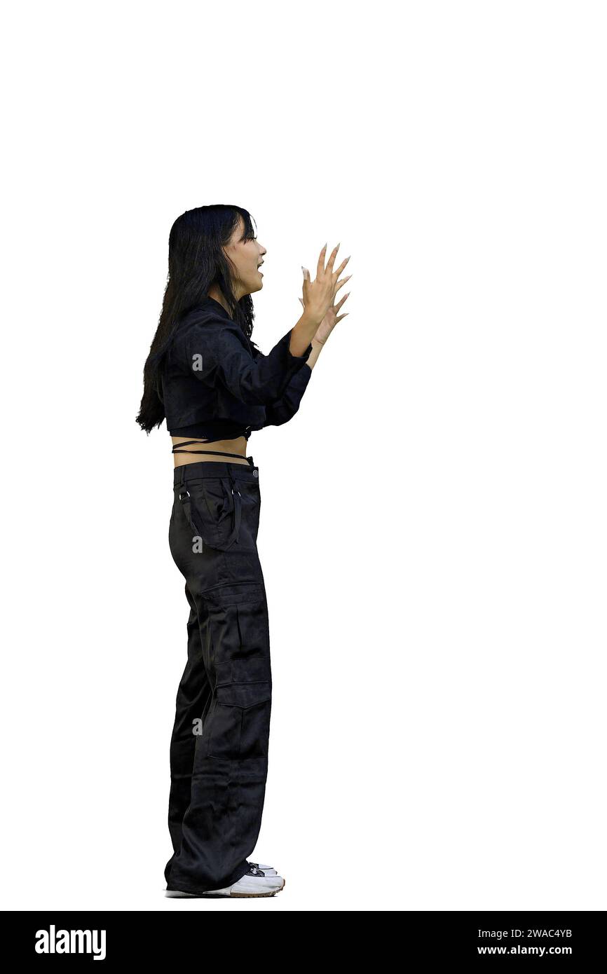 Eine Frau in schwarzer Kleidung, auf weißem Hintergrund, in voller Höhe, spreizt ihre Arme Stockfoto