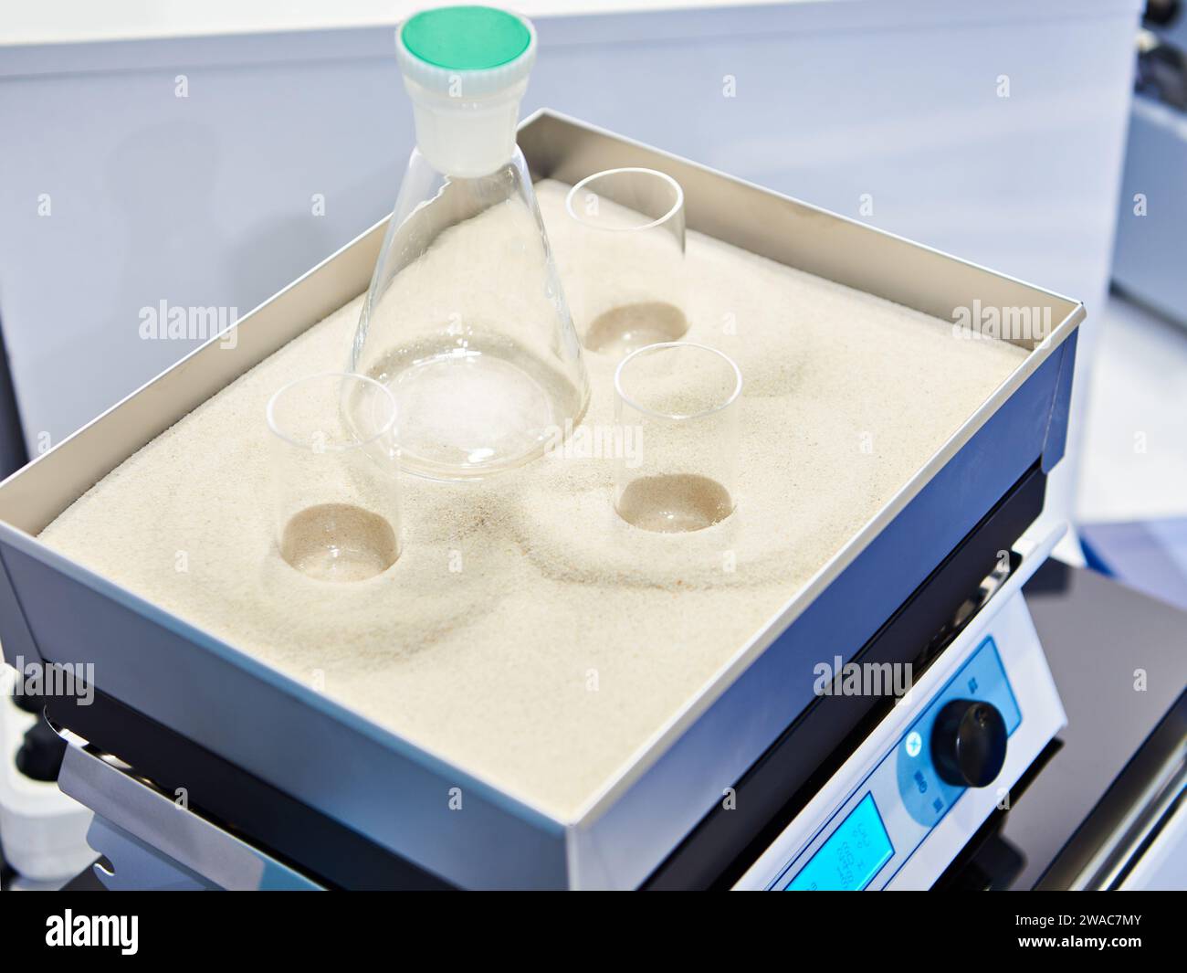 Laborheizofen-Platte mit Reagenzgläsern und Kolben im Sandbad Stockfoto