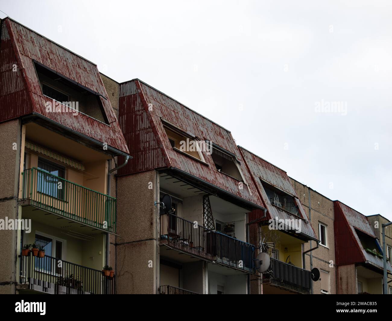 Dunkles Apartmentgebäude mit einer alten Außenfassade. Wohnungen mit Balkonen im osteuropäischen Architekturstil mit vorgefertigten Steinelementen. Stockfoto