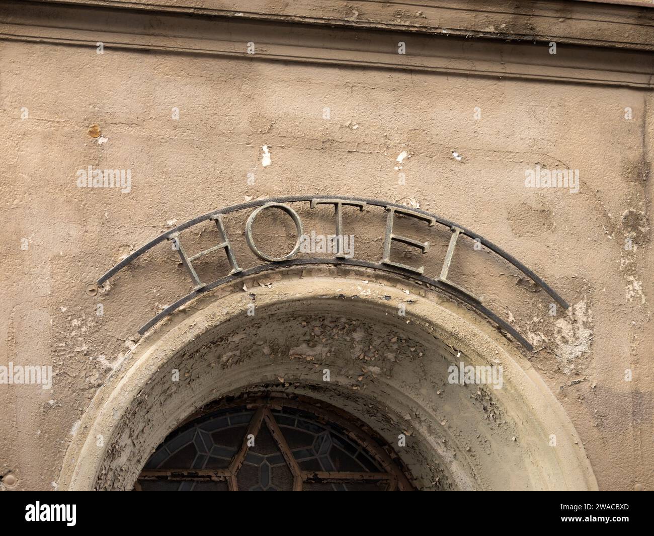 Altes Hotelschild aus Metall über dem Eingang eines alten Gebäudes. Das antike Eisensymbol an der Fassade ist aus nächster Nähe zu sehen. Stockfoto