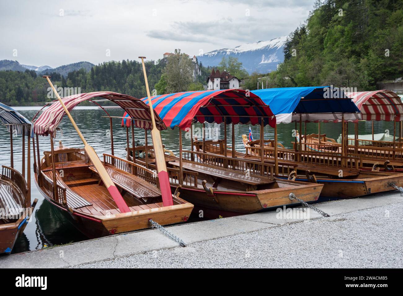 Wenige Boote an einem Ufer des Bleder Sees in Slowenien Stockfoto