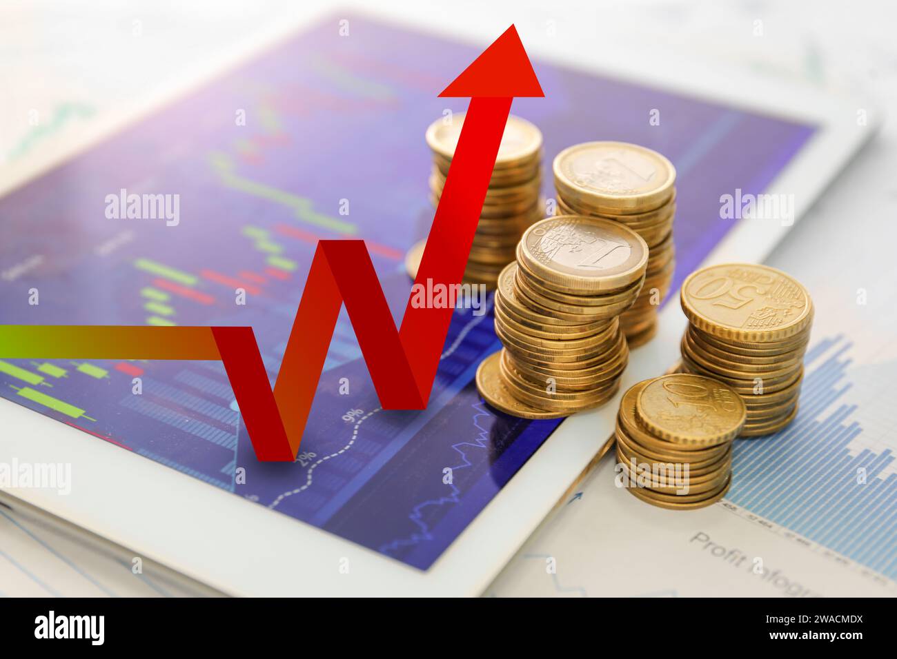 Münzen und Tablet-Computer mit Wechselkursdiagrammen und steigendem Pfeil. Konzept des steigenden Preises Stockfoto