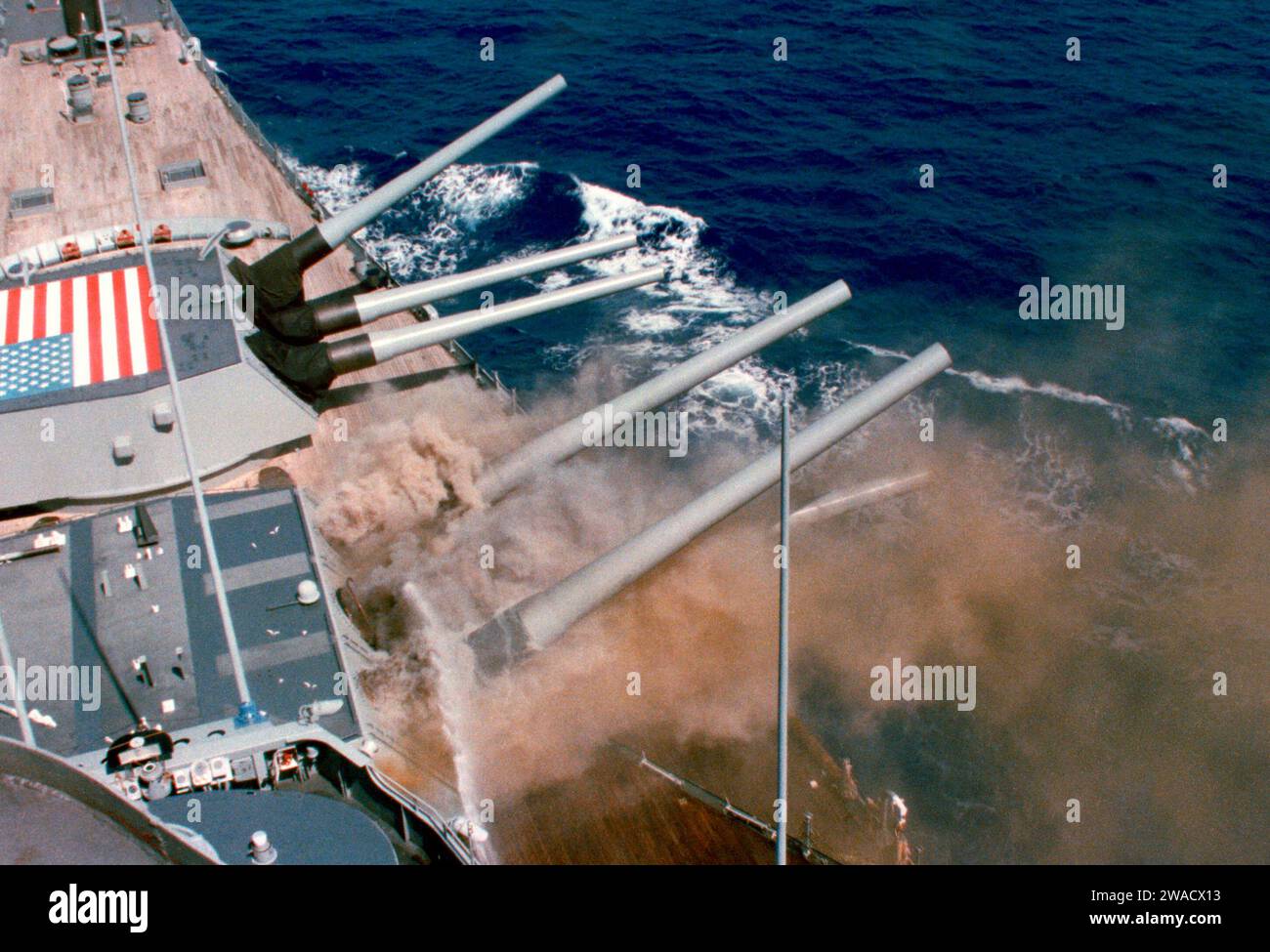 Der 2. Turm der USS Iowa (BB-61) explodierte am 19. April 1989 und tötete 47 Mitglieder der Turmbesatzung. Die linke Kanone von Turret One im Hintergrund ist vollständig angehoben, während die Besatzung versucht, eine Fehlzündung zu beseitigen, die früher aufgetreten ist, indem sie versucht, die Pulverbeutel dazu zu bringen, rückwärts gegen die Primer zu gleiten 19. April 1989 Stockfoto