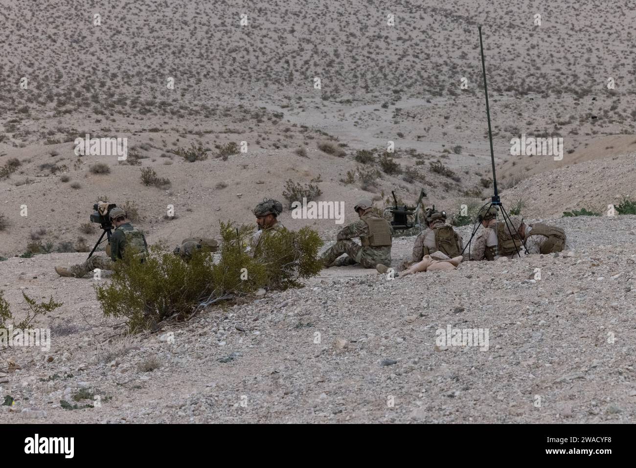 US-Marines, Matrosen und Flieger mit dem Kurs Tactical Air Control Party der Expeditionary Warfare Training Group Pacific, beobachten Sie das Zielgebiet, bevor Sie während einer Live-Feuerübung im Marine Corps Air Ground Combat Center Twentynine Palms, Kalifornien, den 19. Dezember 2023 zum Feuer rufen. Der TACP-Kurs der EWTGPAC bildet gemeinsame Offiziere und Koalitionsoffiziere sowie das angeworbene Personal aus, um die Kontrolle über den Angriffsschutz an der Endstation der Luftunterstützung zu übernehmen. Der TACP-Kurs besteht aus gemeinsamen Angriffskontrolleuren am Terminal, vorderen Fluglotsen, gemeinsamen Feuerbeobachtern und Luftfahrzeugoffizieren. (Foto des U.S. Marine Corps von Lance CPL Stockfoto