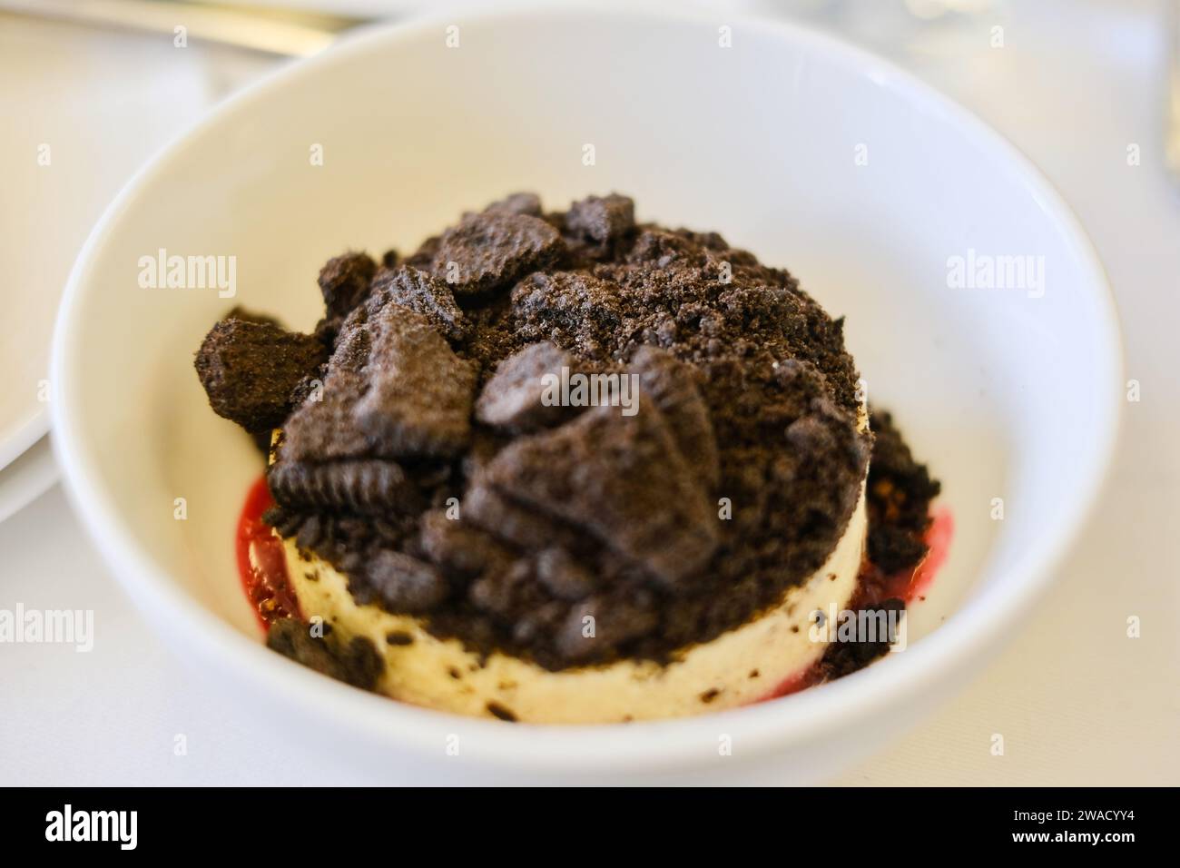 Ein Dessert mit Keksen und Creme-Käsekuchen mit Himbeercoulis, serviert auf einem Flug der Business Class von Sydney, Australien nach Kuala Lumpur, Malaysia Stockfoto